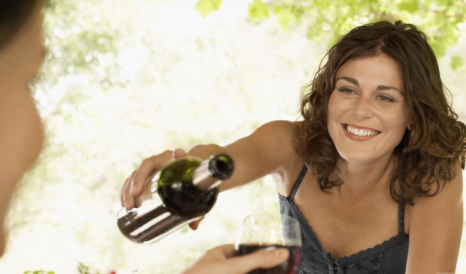 A perfect fit for the whole family a woman pouring wine into a glass